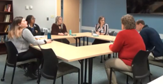 Photo of people sitting around a table talking